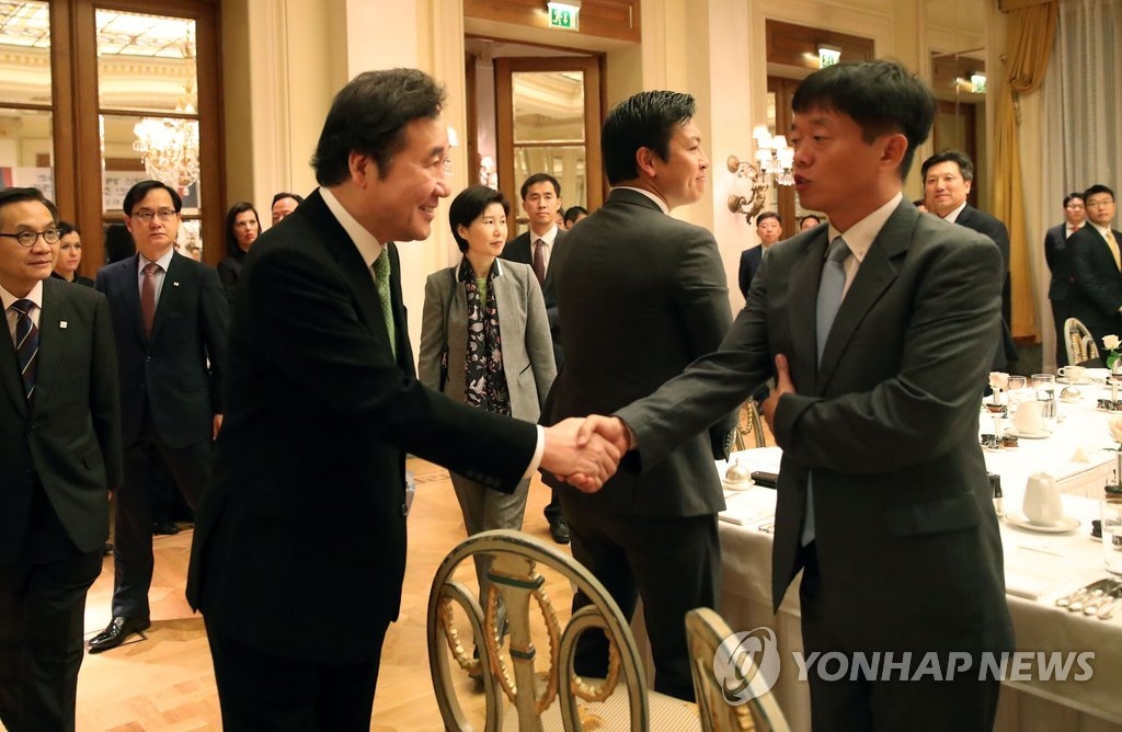 李洛渊在希腊雅典出席当地韩国企业家代表早餐座谈会并同与会代表握手