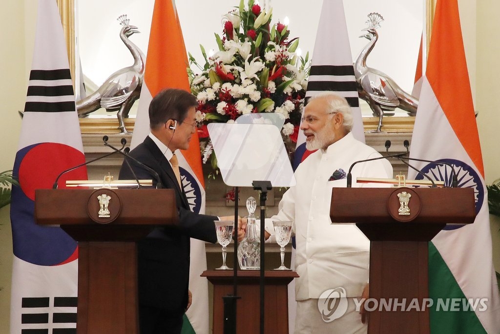 7月10日下午,韩国总统文在寅(左)和印度总理莫迪发布联合新闻稿前握手