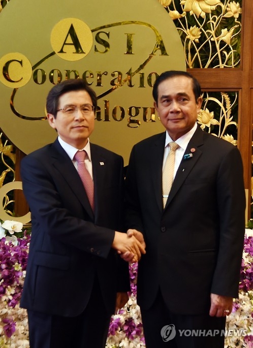 韩国国务总理黄教安(左)和泰国总理巴育·占奥差握手(韩联社)
