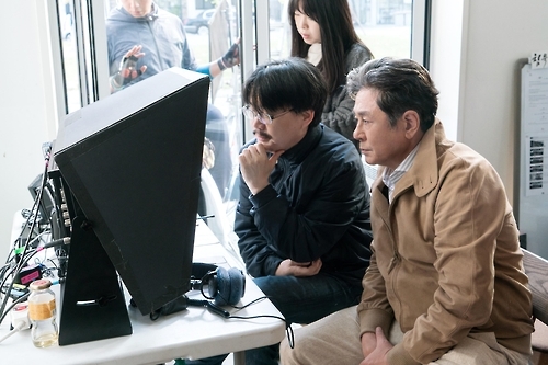 资料图片：图为《沉默》拍摄现场，导演郑址宇（左）与崔岷植一道观看拍摄内容。(YONG FILM提供)