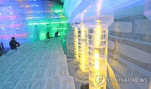 资料图片：世界最大室内冰雕节开幕前，冰雕师正在雕刻作品。（韩联社）