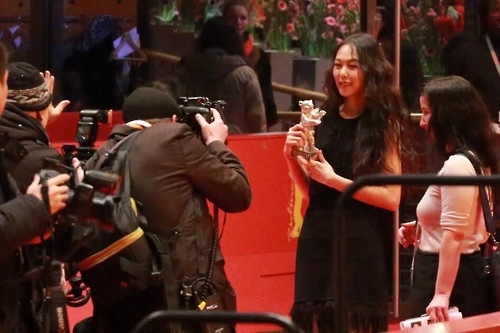 图为演员金敏喜向媒体展示其银熊奖。