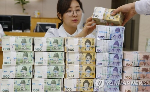 资料图片：银行职员在清点现金。（韩联社）