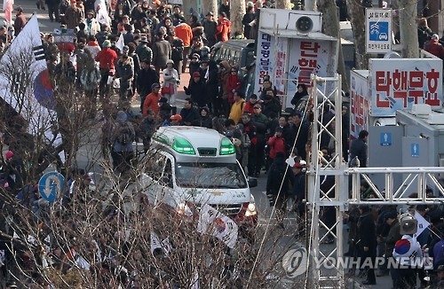 3月10日，在首尔地铁三号线安国站附近，一辆急救车抵达反对弹劾集会现场移送伤者。（韩联社）