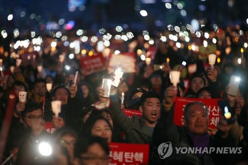 3月11日晚，在首尔光化门广场，烛光集会参加者们高喊口号。（韩联社）