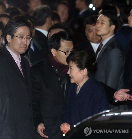朴槿惠乘车抵达私邸后下车，面带微笑。（韩联社）
