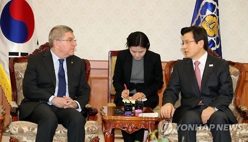 3月14日，在首尔，代行总统职权的韩国总理黄教安（左）会见国际奥委会主席托马斯·巴赫。（韩联社）