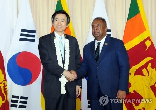 当地时间3月15日，在科伦坡，韩国外交部长官尹炳世（左）与斯里兰卡外交部长萨马拉维拉在会谈前握手合影留念。（韩联社/韩国外交部提供）