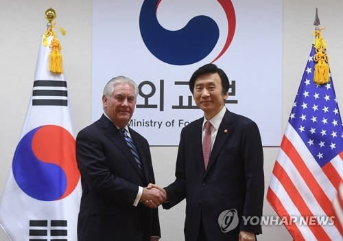 3月17日下午，在首尔，韩美两国外长在会谈前握手。（韩联社）