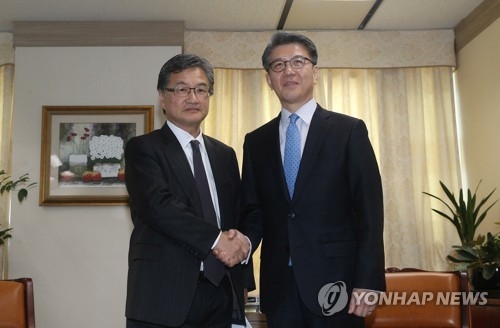 3月22日，六方会谈韩方团长金烘均（右）和美方团长约瑟夫·尹会晤前亲切握手。（韩联社）