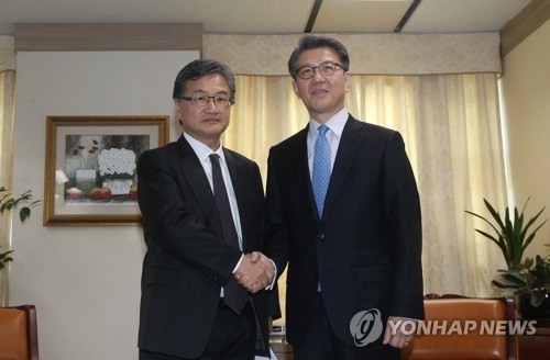 3月22日，在首尔韩国外交部大楼，朝核问题六方会谈韩方团长、韩国外交部韩半岛和平交涉本部长金烘均（右）同美方团长、美国国务院对朝政策特别代表约瑟夫·尹握手合影。（韩联社）