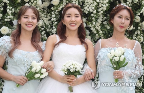 Bada（中）大婚，S.E.S柳真（左）和Shoo齐穿婚纱展情义。（韩联社）