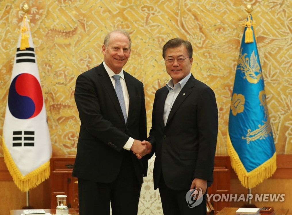 韩国总统文在寅(右)与美国外交学会会长理查德·哈斯握手合影