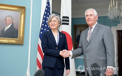 资料图片：6月28日（当地时间），在华盛顿，韩国外交部长官康京和（左）和美国国务卿蒂勒森亲切握手合影。（韩联社/韩国外交部提供）