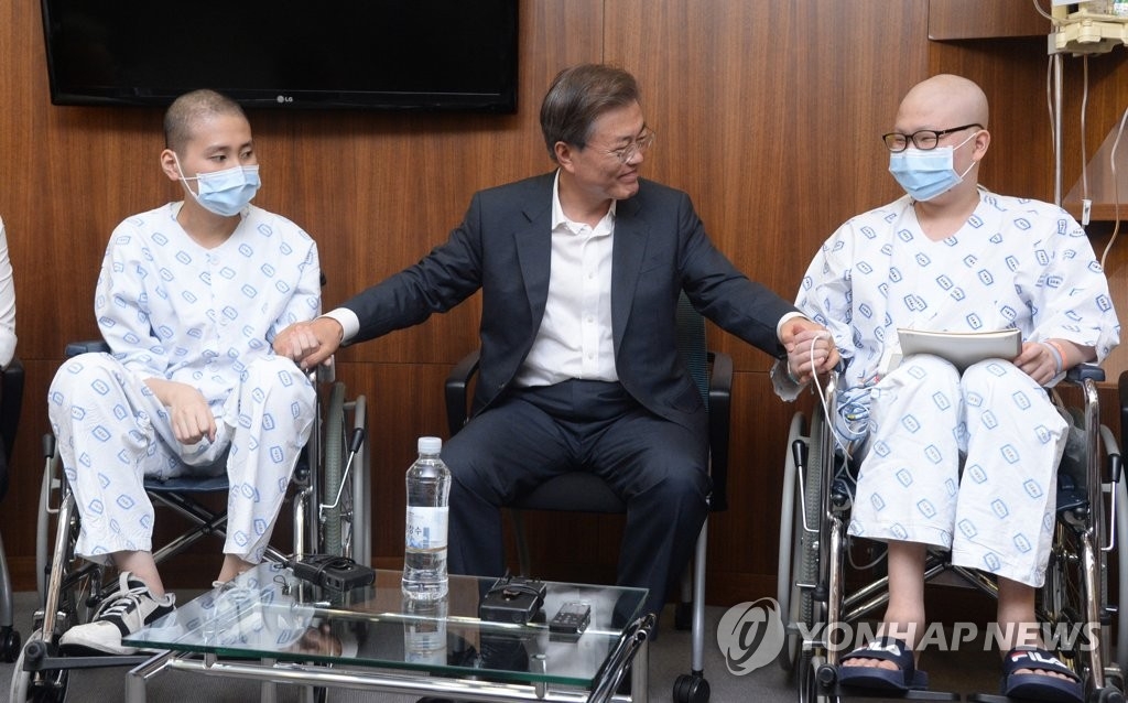 8月9日，文在寅（左二）访问位于首尔瑞草区的首尔圣母医院，并与病人亲切交谈。（韩联社）