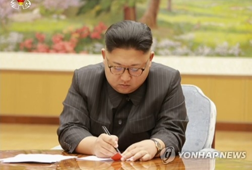 朝鲜中央电视台9月3日播出的画面中，金正恩似在洲际弹道导弹氢弹头试验命令书上签字。图片仅限韩国国内使用，严禁转载复制。（韩联社/朝鲜中央电视台）