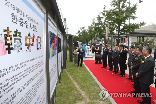 9月5日下午，在位于首尔光化门的大韩民国历史博物馆，出席“祝愿2018平昌冬奥会成功的韩中日首尔图片展”开幕式的人士在听取图片介绍。（韩联社）