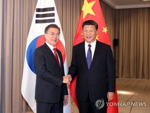 资料图片：当地时间7月6日，在德国柏林，韩国总统文在寅（左）与中国国家主席习近平握手合影。（韩联社）