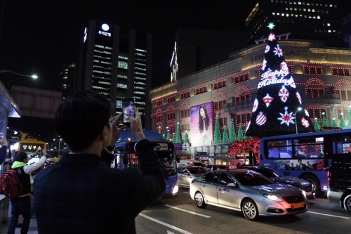 资料图片：新世界百货总店前的圣诞树吸引游客眼球。（韩联社/新世界百货提供）