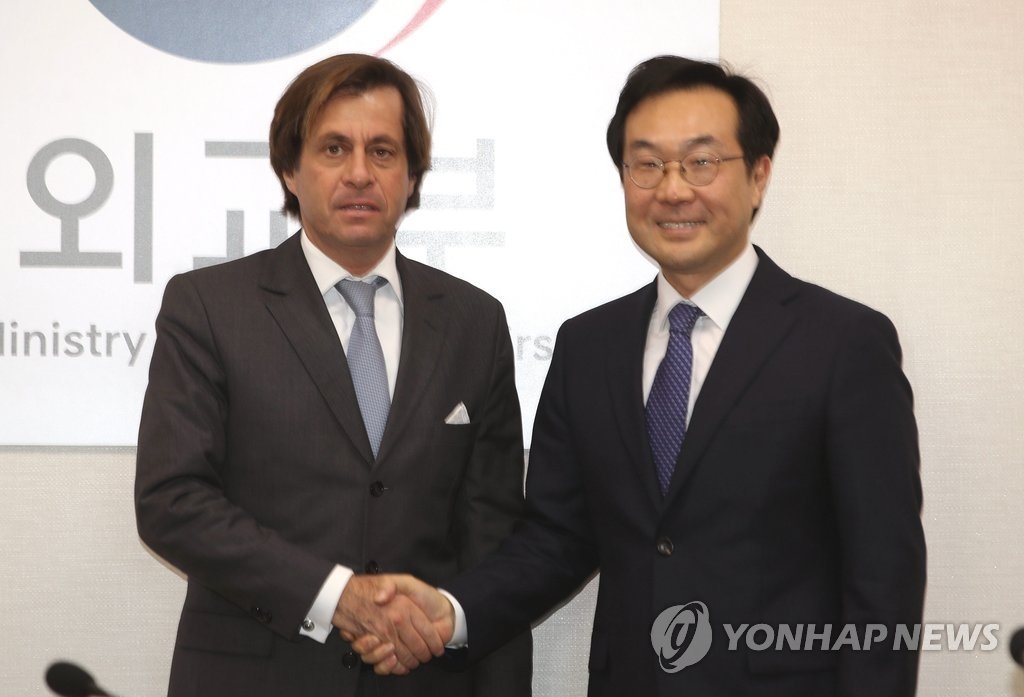 12月5日下午，在首尔韩国外交部大楼，外交部韩半岛和平交涉本部长李度勋（右）与法国外交部政治总司长尼古拉·德·里维埃举行会晤前合影。（韩联社）