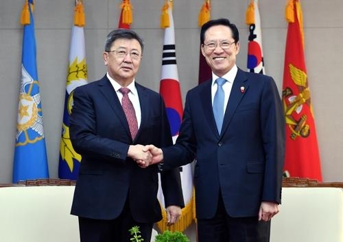 宋永武（右）和蒙古国防长恩赫包勒德握手。（韩联社/国防部提供）
