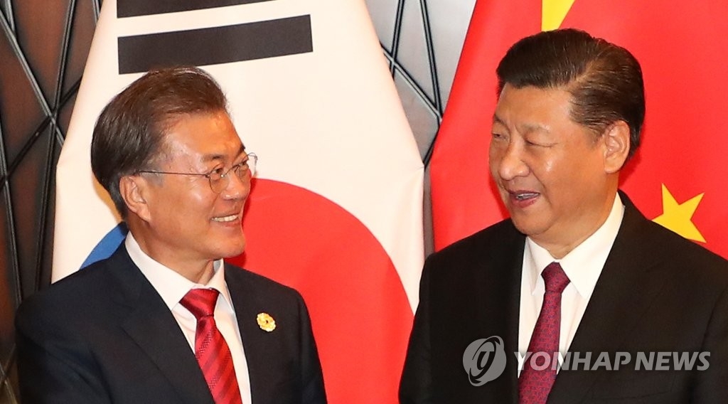 资料图片：11月11日，在亚太经合组织（APEC）领导人非正式会议上，韩国总统文在寅（左）与中国国家主席习近平举行首脑会谈。（韩联社）