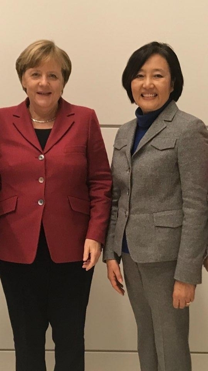 韩国共同民主党议员朴映宣（右）和德国总理默克尔合影。（韩联社）