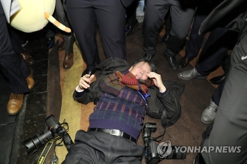 12月14日，在北京国家会议中心，一名韩国摄影记者遭中方警卫殴打躺倒在地。（韩联社）