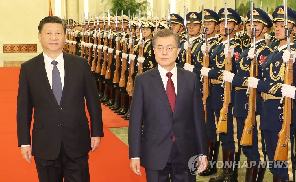 12月14日下午，在北京人民大会堂举行的欢迎仪式上，文在寅（右）和习近平检阅仪仗队。（韩联社）