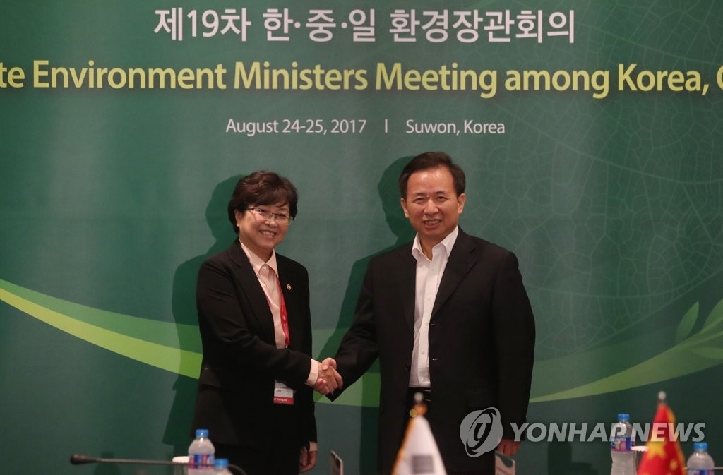 资料图片：8月24日，韩国环境部长官金恩京同中国环境保护部部长李干杰出席第19届韩中日环境部长会议并握手致意。（韩联社） 