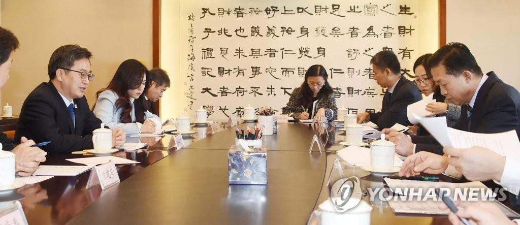 12月15日，在中国北京，韩财长金东兖（左）同中国财政部长肖捷举行会谈。（韩联社/企划财政部提供）