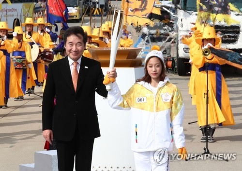 11月1日，在仁川大桥，花滑新星柳英从韩国总理李洛渊手中接过平昌冬奥火炬。（韩联社）