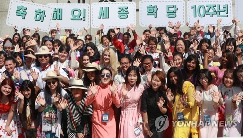 资料图片：9月18日，在首尔光化门广场，参加“世宗学堂优秀学习者培训”的外国人合影留念。（韩联社）
