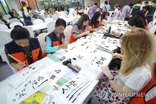 资料图片：去年9月，在首尔，参加“世宗学堂优秀学习者培训”的外国人体验书法。（韩联社）