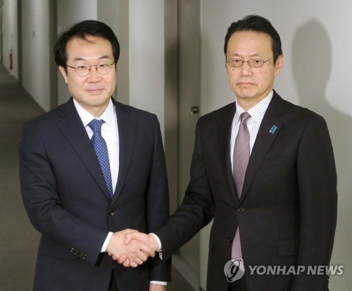 12月22日，在日本东京，朝核问题六方会谈韩方团长、外交部韩半岛和平交涉本部长李度勋（左）与日方团长、日本外务省亚洲大洋洲局局长金杉宪治握手合影。（韩联社）