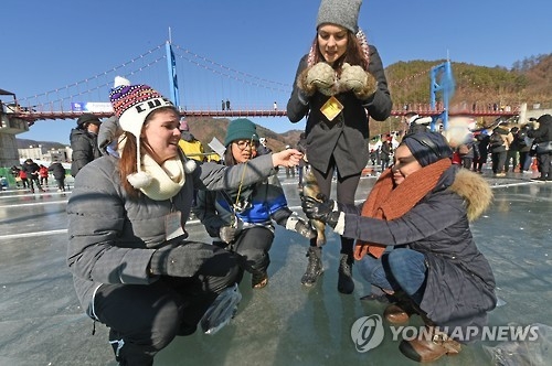 资料图片：外国游客在华川山鳟鱼庆典体验冰钓。（韩联社） 