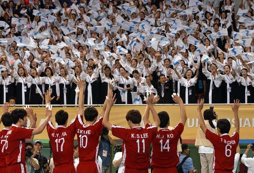 资料图片：朝鲜拉拉队在2003年大邱夏季世界大学生运动会的男排决赛上为韩国选手欢呼加油。（韩联社）