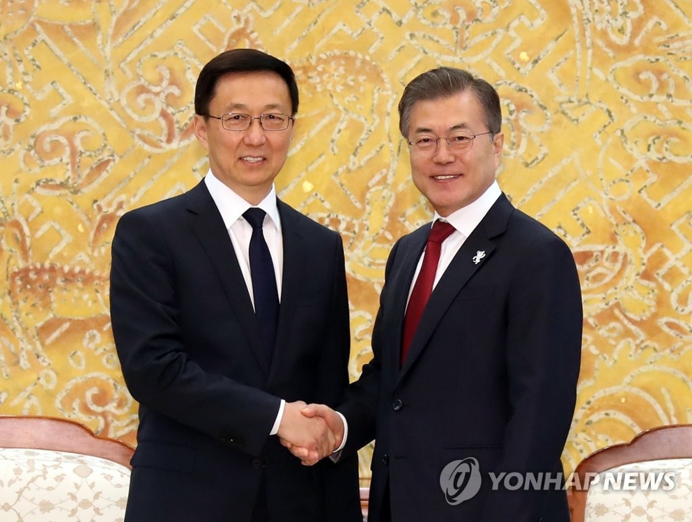 2月8日，在青瓦台，韩国总统文在寅（右）会见中共中央政治局常委韩正。图为双方握手合影。（韩联社）