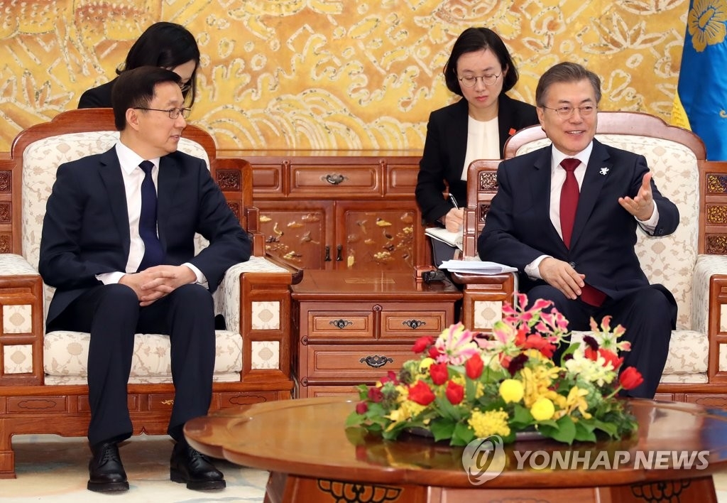 2月8日，在青瓦台，韩国总统文在寅（右）会见中共中央政治局常委韩正。（韩联社）