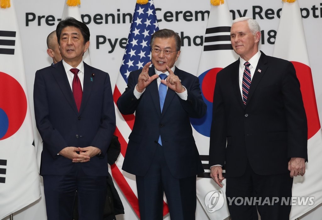 2月9日下午，在平昌，韩国总统文在寅（中）同日本首相安倍晋三（左）、美国副总统彭斯在各国领导人招待会上合影。（韩联社）