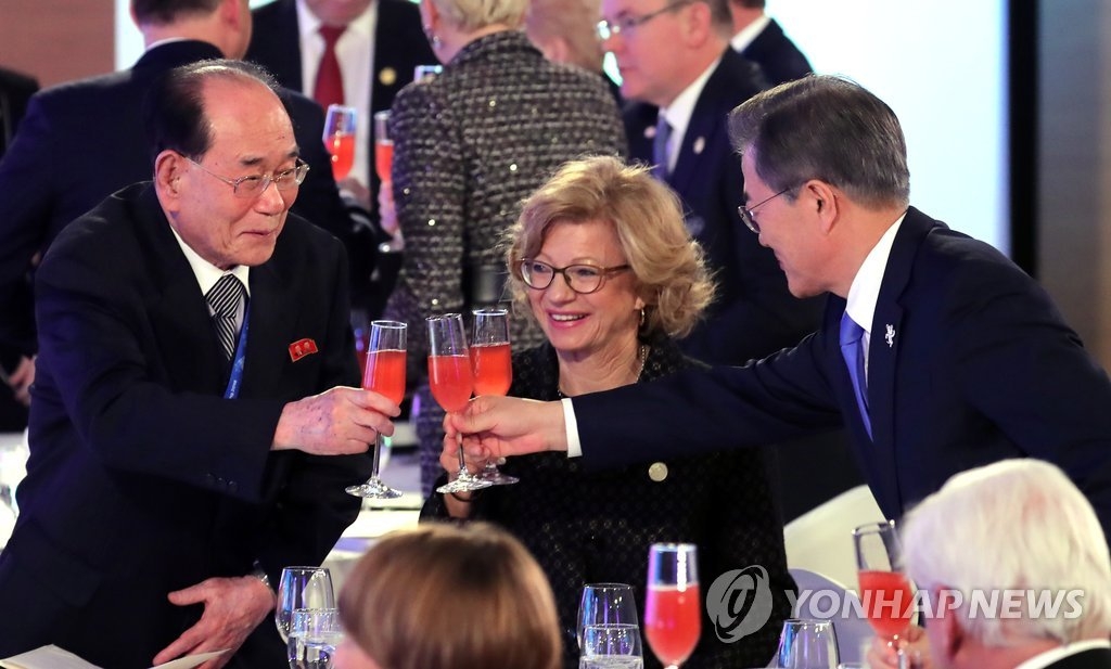 2月9日下午，在平昌，韩国总统文在寅（右）同朝鲜最高人民会议常任委员会委员长金永南（左）在各国领导人招待会上举杯致意。（韩联社）