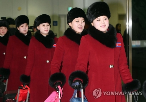 资料图片：2月7日上午，在京畿道坡州市都罗山南北出入境事务所（CIQ），身着红衣、胸戴朝鲜“国旗”徽章的朝鲜拉拉队成员走入韩国境内。（韩联社/联合采访团）