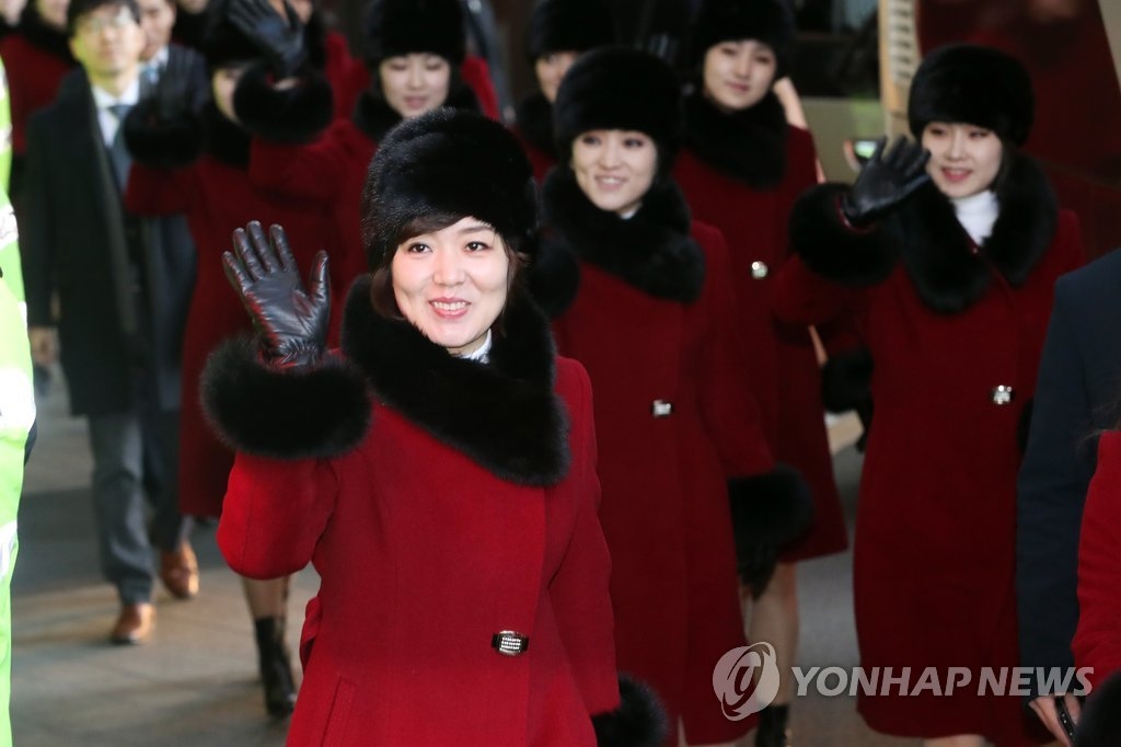 2月12日，在首尔一家酒店，朝鲜艺术团团员乘车前挥手致意。（韩联社）