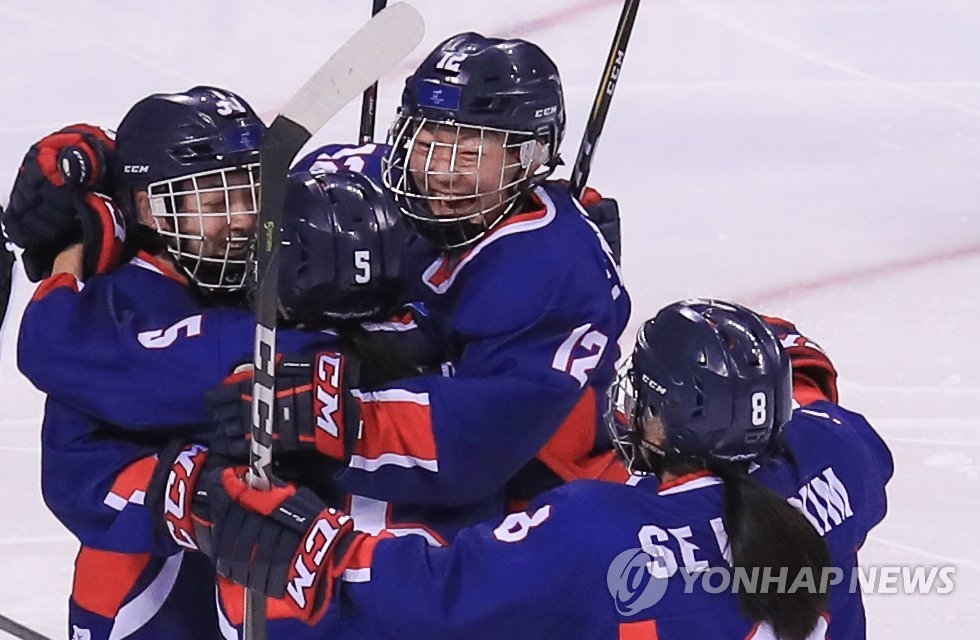 2月14日，在江原道关东冰球中心举行的冬奥冰球女子B组小组赛韩朝联队和日本队比赛中，韩朝联队攻入一球后与队友拥抱庆祝。（韩联社）
