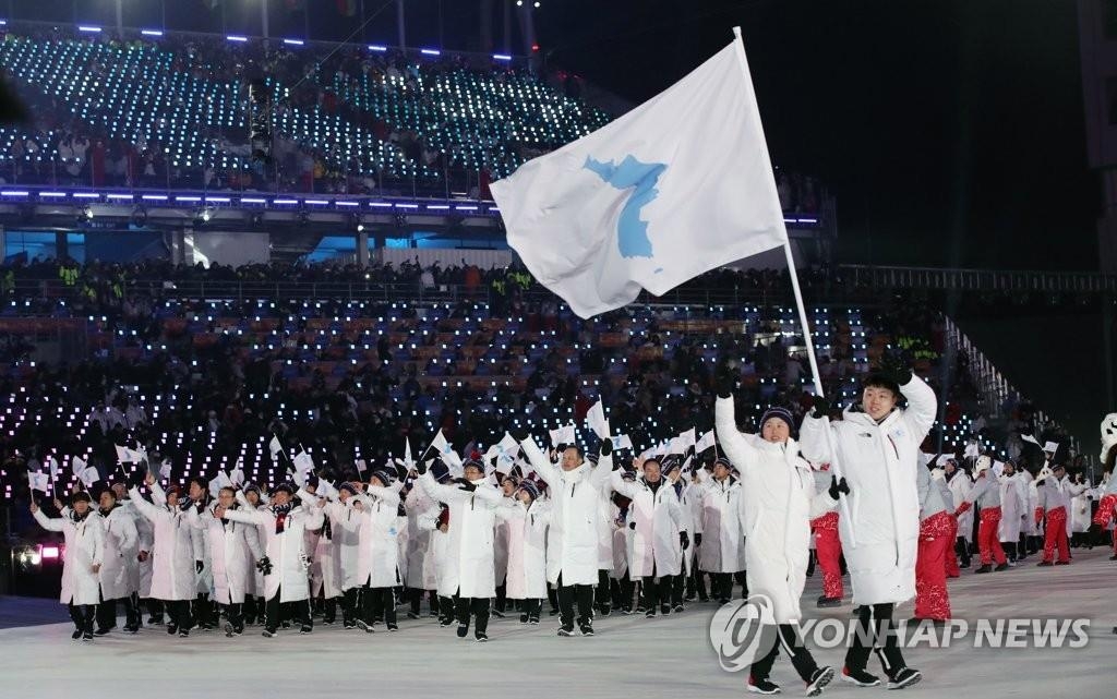 资料图片：2月9日，在江原道平昌奥林匹克体育场举行的2018平昌冬奥会开幕式上，韩朝代表团举半岛旗共同入场。（韩联社）