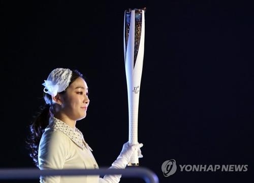 2月9日，在平昌冬奥会开幕式上，金妍儿准备点燃主火炬。（韩联社）