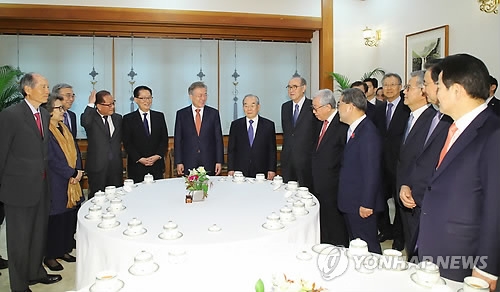 4月12日下午，在青瓦台，韩国总统文在寅（左六）与文金会顾问团共进午餐前交谈。（韩联社）