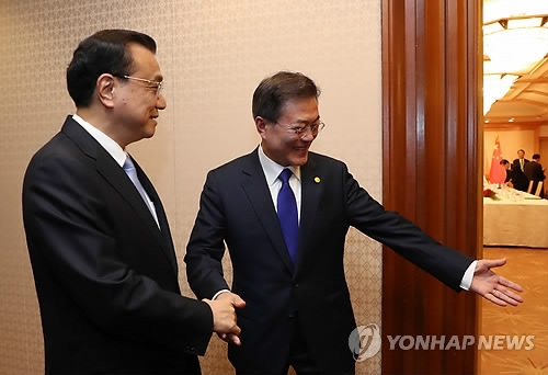 右为韩国总统文在寅，左为中国国务院总理李克强。（韩联社） 