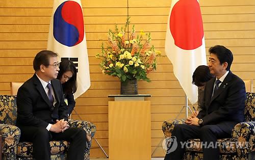资料图片：3月13日，在日本首相官邸，徐薰（左）向日本首相安倍晋三说明金特会筹备情况。（韩联社）