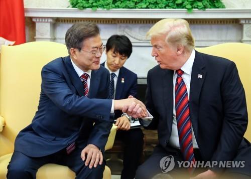 资料图片：当地时间5月22日，在美国白宫，韩国总统文在寅（左）同美国总统特朗普握手。（韩联社）